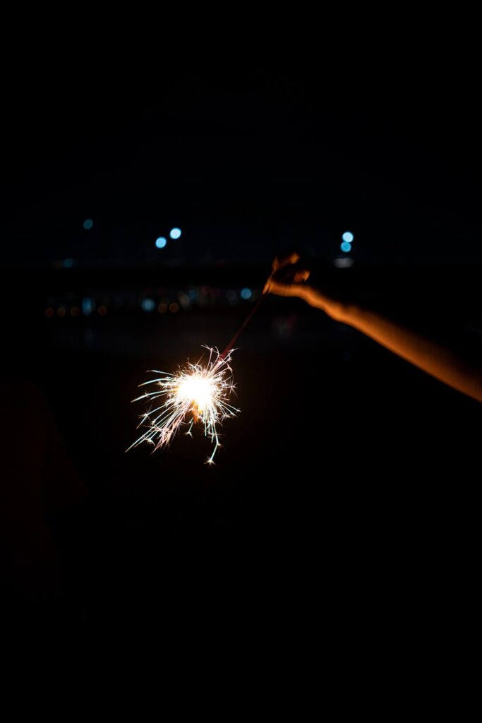 person holding sparkler during nighttime